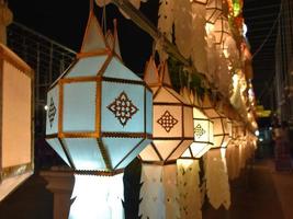 Beautifully shaped and colorful paper lanterns are hung in front of a pagoda to worship Lord Buddha in a temple in northern Thailand. photo