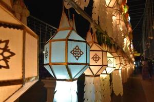 Beautifully shaped and colorful paper lanterns are hung in front of a pagoda to worship Lord Buddha in a temple in northern Thailand. photo