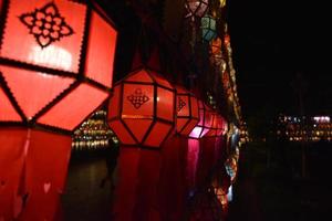Beautifully shaped and colorful paper lanterns are hung in front of a pagoda to worship Lord Buddha in a temple in northern Thailand. photo