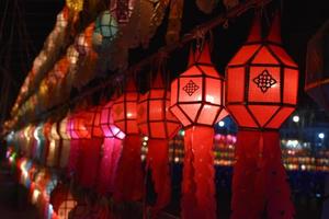 Beautifully shaped and colorful paper lanterns are hung in front of a pagoda to worship Lord Buddha in a temple in northern Thailand. photo