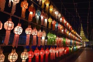 Beautifully shaped and colorful paper lanterns are hung in front of a pagoda to worship Lord Buddha in a temple in northern Thailand. photo