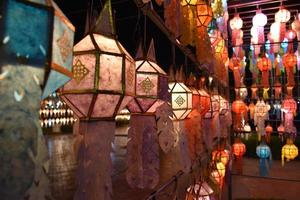 Beautifully shaped and colorful paper lanterns are hung in front of a pagoda to worship Lord Buddha in a temple in northern Thailand. photo