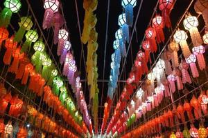 Beautifully shaped and colorful paper lanterns are hung in front of a pagoda to worship Lord Buddha in a temple in northern Thailand. photo