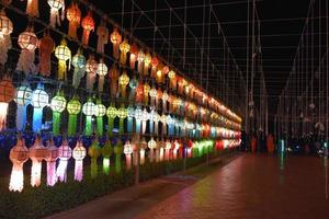 Beautifully shaped and colorful paper lanterns are hung in front of a pagoda to worship Lord Buddha in a temple in northern Thailand. photo