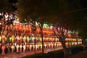Beautifully shaped and colorful paper lanterns are hung in front of a pagoda to worship Lord Buddha in a temple in northern Thailand. photo