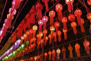Beautifully shaped and colorful paper lanterns are hung in front of a pagoda to worship Lord Buddha in a temple in northern Thailand. photo