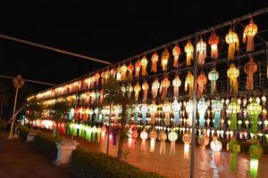 Beautifully shaped and colorful paper lanterns are hung in front of a pagoda to worship Lord Buddha in a temple in northern Thailand. photo