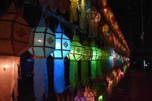 Beautifully shaped and colorful paper lanterns are hung in front of a pagoda to worship Lord Buddha in a temple in northern Thailand. photo