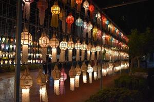 Beautifully shaped and colorful paper lanterns are hung in front of a pagoda to worship Lord Buddha in a temple in northern Thailand. photo
