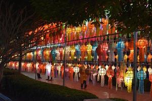 Beautifully shaped and colorful paper lanterns are hung in front of a pagoda to worship Lord Buddha in a temple in northern Thailand. photo
