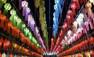 Linternas de papel bellamente formadas y coloridas se cuelgan frente a una pagoda para adorar al Señor Buda en un templo en el norte de Tailandia. foto