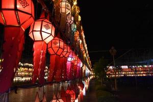 Beautifully shaped and colorful paper lanterns are hung in front of a pagoda to worship Lord Buddha in a temple in northern Thailand. photo