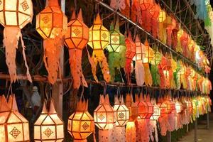 Beautifully shaped and colorful paper lanterns are hung in front of a pagoda to worship Lord Buddha in a temple in northern Thailand. photo