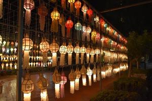 Beautifully shaped and colorful paper lanterns are hung in front of a pagoda to worship Lord Buddha in a temple in northern Thailand. photo