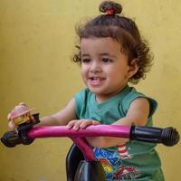 lindo niño pequeño shivaay conduciendo en bicicleta en el balcón de la casa durante el verano, dulce sesión de fotos de niño pequeño durante el día, niño pequeño disfruta de andar en bicicleta en casa durante la sesión de fotos