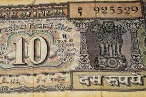 vista de cerca de una rara nota de diez rupias sobre la mesa, viejos billetes de moneda india en una mesa giratoria, vista de cerca de moneda india rara foto