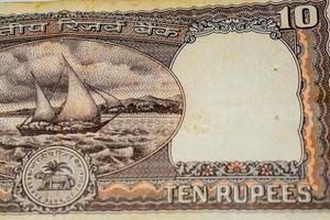 vista de cerca de una rara nota de diez rupias sobre la mesa, viejos billetes de moneda india en una mesa giratoria, vista de cerca de moneda india rara foto