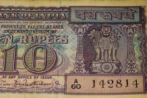 vista de cerca de una rara nota de diez rupias sobre la mesa, viejos billetes de moneda india en una mesa giratoria, vista de cerca de moneda india rara foto