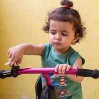 lindo niño pequeño shivaay conduciendo en bicicleta en el balcón de la casa durante el verano, dulce sesión de fotos de niño pequeño durante el día, niño pequeño disfruta de andar en bicicleta en casa durante la sesión de fotos