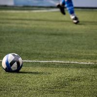 New Delhi, India - July 01 2018 Footballers of local football team during game in regional Derby championship on a bad football pitch. Hot moment of football match on grass green field of the stadium photo