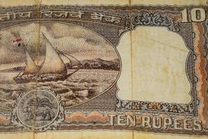 vista de cerca de una rara nota de diez rupias sobre la mesa, viejos billetes de moneda india en una mesa giratoria, vista de cerca de moneda india rara foto