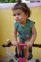 lindo niño pequeño shivaay conduciendo en bicicleta en el balcón de la casa durante el verano, dulce sesión de fotos de niño pequeño durante el día, niño pequeño disfruta de andar en bicicleta en casa durante la sesión de fotos