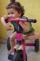 lindo niño pequeño shivaay conduciendo en bicicleta en el balcón de la casa durante el verano, dulce sesión de fotos de niño pequeño durante el día, niño pequeño disfruta de andar en bicicleta en casa durante la sesión de fotos