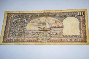 raro viejo billete indio de diez rupias sobre fondo blanco, gobierno de la india diez rupias billete antiguo moneda india, antiguo billete indio sobre la mesa foto