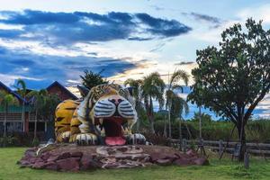 Beautiful sculpture of tiger statue at sunset sky on blue and yellow background photo