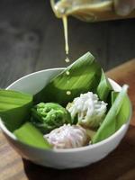 vista de ángulo alto del plato de tolva de cadena betawi indonesio llamado pastel putu mayang, con forma de fideos, servido con w foto