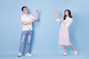 Full length image of young Asian couple on blue background photo