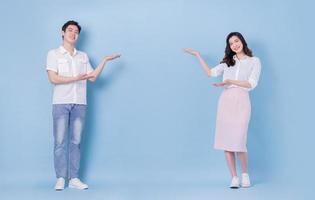 Full length image of young Asian couple on blue background photo