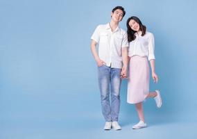 Full length image of young Asian couple on blue background photo