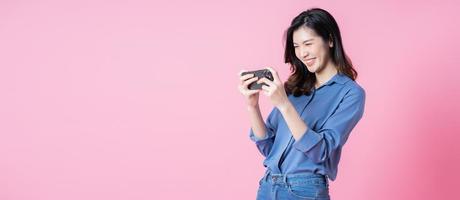 imagen de una joven mujer de negocios asiática usando un smartphone con fondo rosa