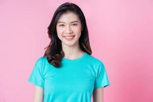 Portrait of young Asian woman on pink background photo