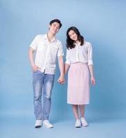 Full length image of young Asian couple on blue background photo