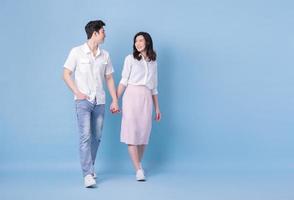 Full length image of young Asian couple on blue background photo