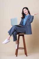 Full length image of young Asian business woman on background photo