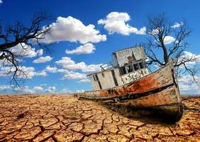 barcos en una tierra yerma. un barco en una tierra quebrada. el concepto de sequía, calentamiento global y medio ambiente. foto
