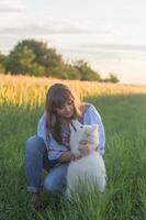 portrait of woman and white puppy of husky dog in the fields photo