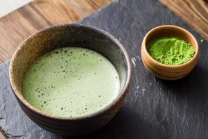 green matcha tea prepearing on stone black table photo