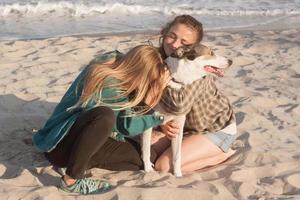 Woman play with dog on the beach photo