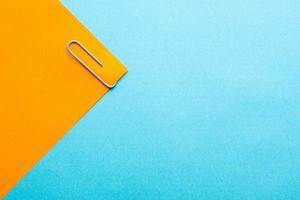 Minimalist background with blue paper clip on colorful background with free copy paste space for text. photo