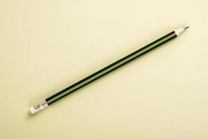 Wooden pencil in green and black colors on cheam white background with copy space or text. photo