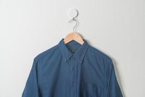 hanging shirt with wood hanger on wall photo