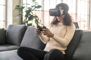 Mujer latina con un casco de realidad virtual en el sofá foto