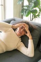 mujer latina, acostado, en, sofá, con, dolor de cabeza, sentimiento foto