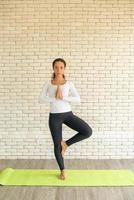 Latin woman practicing yoga on mat photo