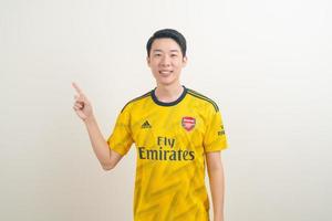 Bangkok, Tailandia - 27 de noviembre de 2021 - joven asiático vistiendo la camiseta del arsenal con fondo blanco. foto