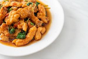 stir-fried fried fish with basil and chili in thai style photo